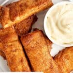 Homemade Pizza Hut cinnamon sticks and a bowl of frosting for dipping.