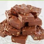 Pieces of homemade See's fudge stacked on a glass platter.