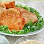 A bowl of homemade shake and bake coating and pork chops on a platter.