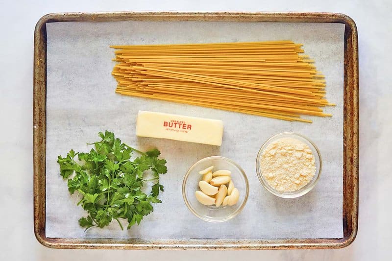 Copycat Spaghetti Warehouse spaghetti with garlic butter ingredients on a tray.