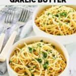 Two forks and two bowls of homemade Spaghetti Warehouse spaghetti with garlic butter.