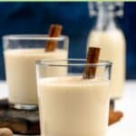 Homemade spiked eggnog in two glasses and a small bottle.