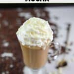 Homemade Starbucks white chocolate mocha with whipped cream in a glass coffee mug.
