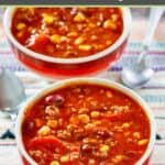 Two bowls of taco soup with ground beef and two spoons.