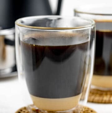 Vietnamese coffee in a mug on top of a coaster.