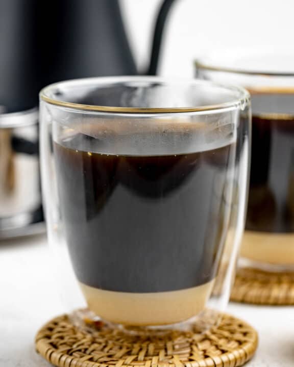 Vietnamese coffee in a mug on top of a coaster.