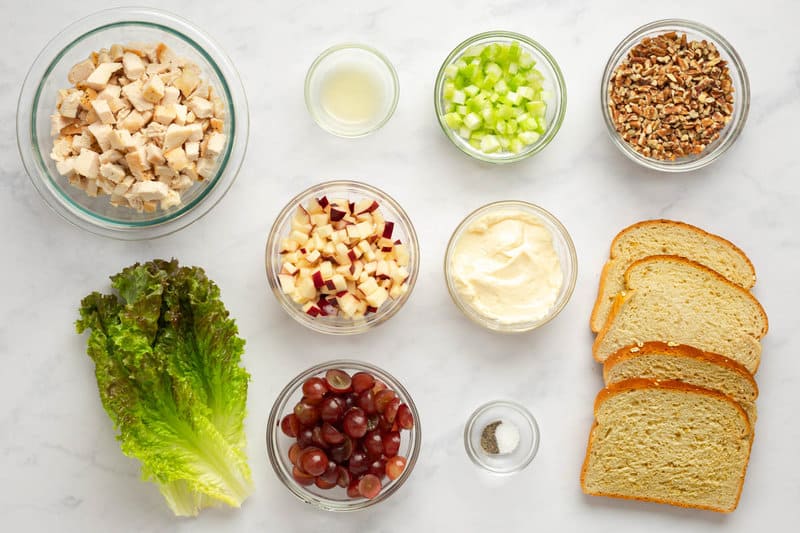 Copycat Arby's pecan chicken salad sandwich ingredients on a marble surface.
