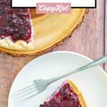 Homemade blueberry cream cheese pie on a serving board and a slice on a plate.