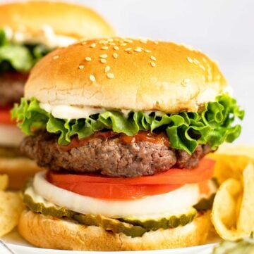 Copycat Burger King Whopper and potato chips on a plate.