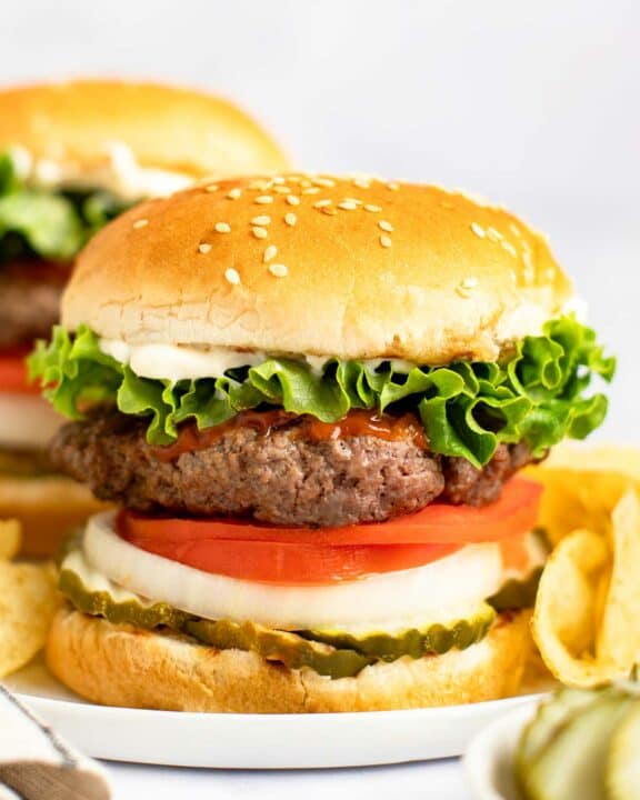 Copycat Burger King Whopper and potato chips on a plate.