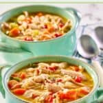 Chicken bisque soup in two bowls and two spoons next to them.