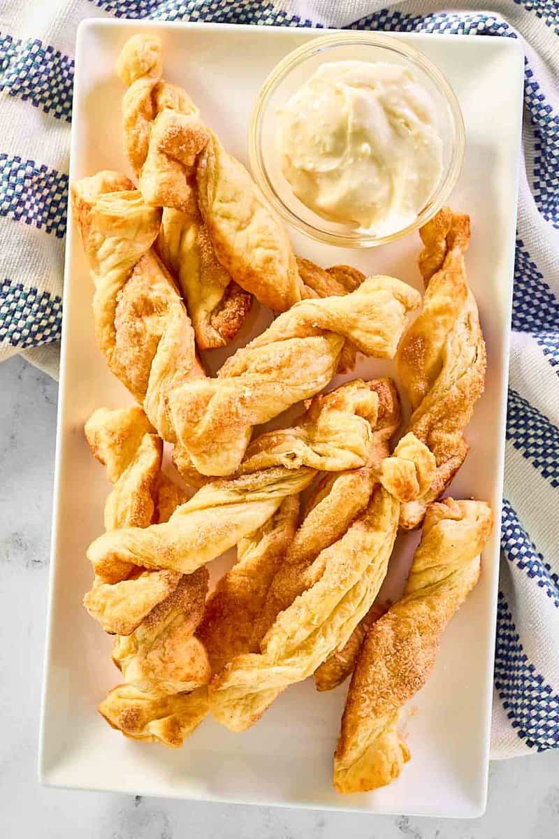 Copycat Cinnabon cinnamon stix and cream cheese frosting dip on a rectangular platter.