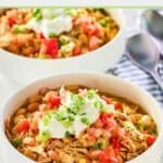 Crockpot white bean chicken chili garnished with sour cream and green onions in two bowls.
