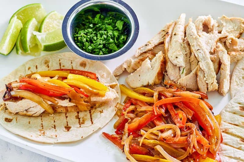 Grilled chicken fajitas on a platter.