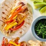 Grilled chicken fajitas on a tortilla.