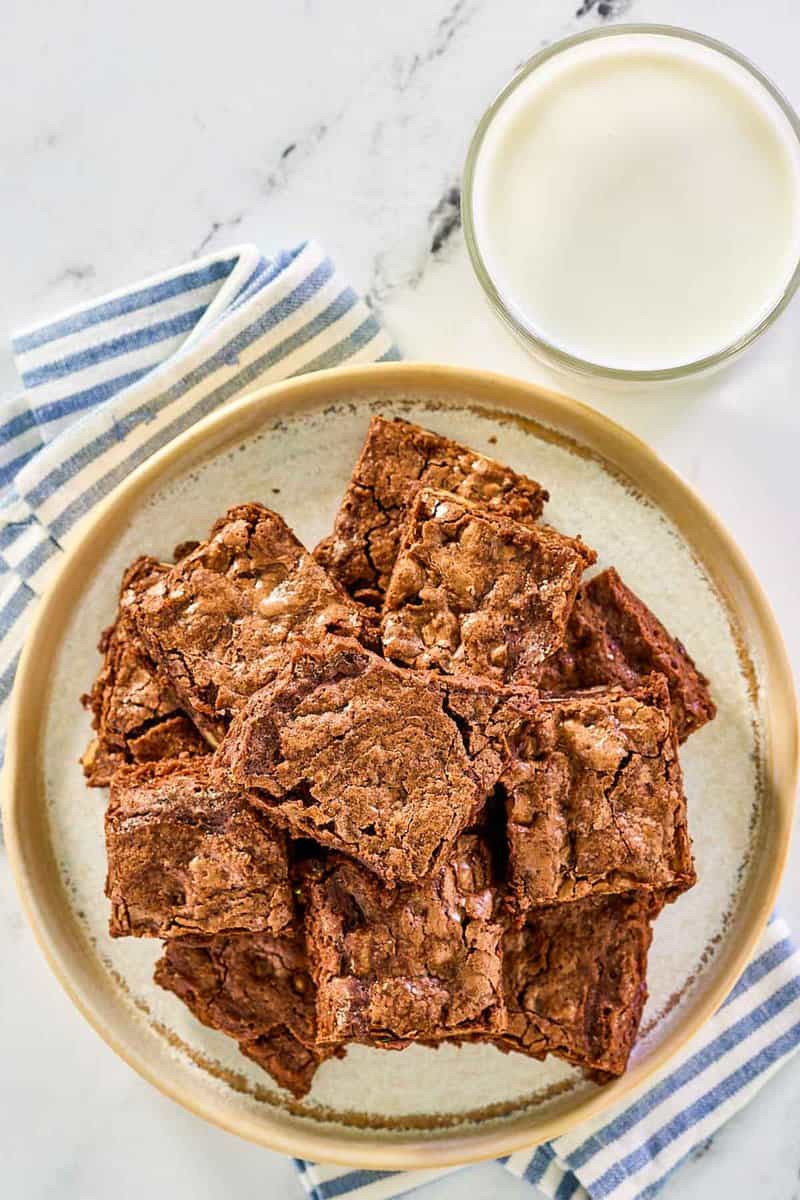 Hershey's brownies on a plate and a glass of milk next to it.