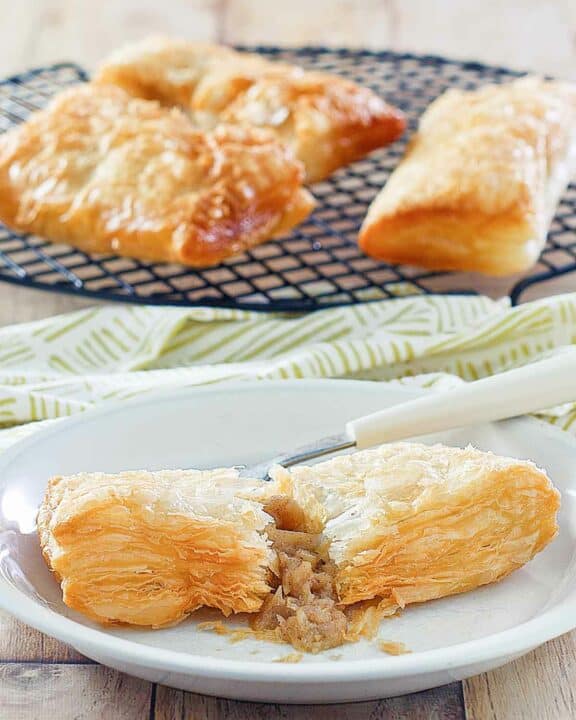 Copycat McDonald's apple pie on a plate and three on a wire rack.
