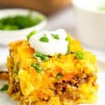 Mexican cornbread casserole topped with sour cream and fresh cilantro.