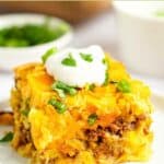 Mexican cornbread casserole topped with fresh cilantro and sour cream.