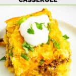 Mexican cornbread casserole serving garnished with sour cream and fresh cilantro.