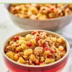 Sausage potato hash in a bowl on top of a cloth napkin.
