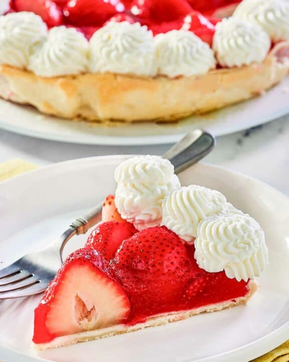 Copycat Shoney's strawberry pie slice on a plate and the pie behind it.