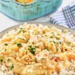 Shrimp and crab au gratin over rice on a plate.