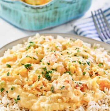 Shrimp and crab au gratin over rice on a plate.