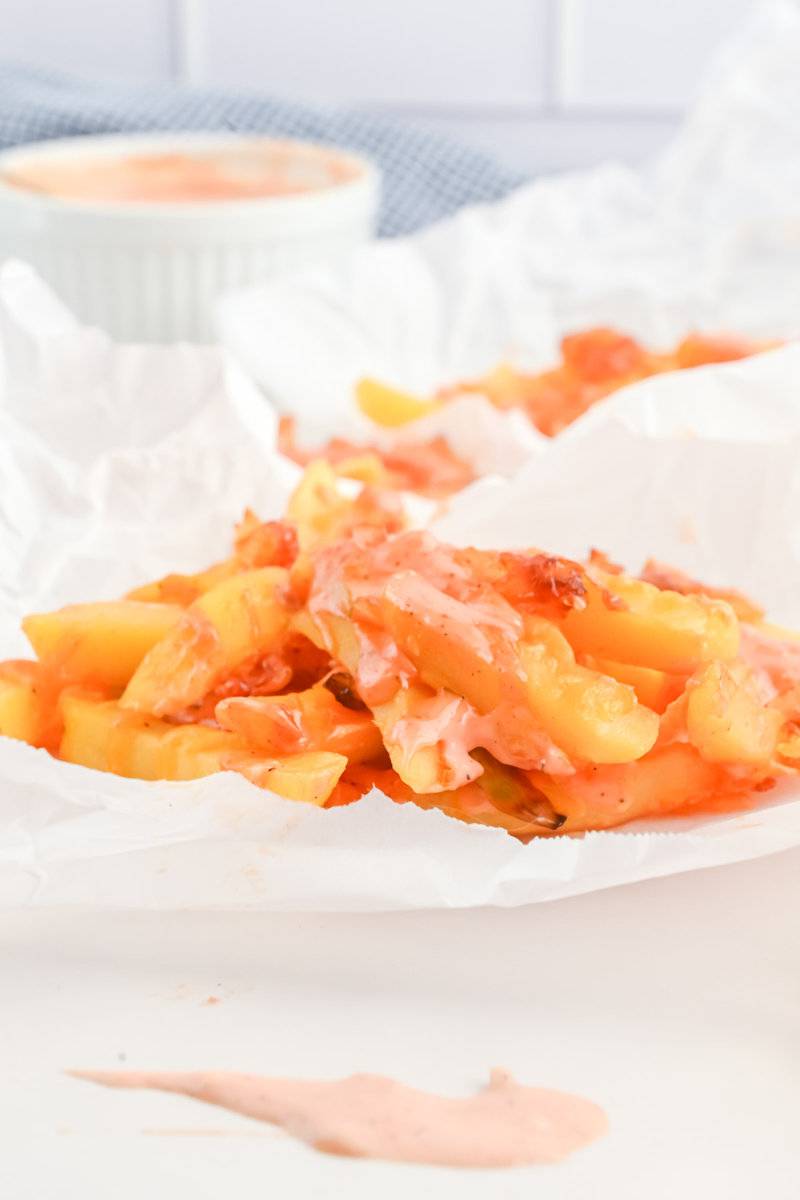 Copycat In-N-Out animal style fries on parchment paper.