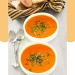 Two bowls of homemade La Madeleine tomato basil soup and two spoons.