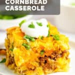 A serving of Mexican cornbread casserole topped with sour cream and cilantro on a plate.