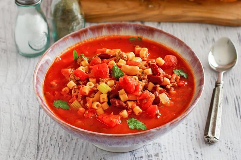 Copycat Olive Garden pasta e fagioli in a bowl and a spoon next to it.
