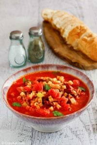 Copycat Olive Garden pasta e fagioli, bread slices, salt, and pepper.