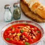 Homemade Olive Garden pasta e fagioli soup, salt, pepper, and bread.
