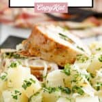 Stuffed pork loin and parsley potatoes on a plate.