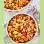 Sausage potato hash in two bowls and a fork next to them.