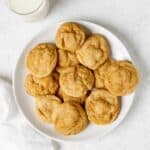 A plate of homemade snickerdoodle cookies and a glass of milk beside it.