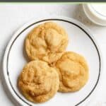 Three homemade snickerdoodle cookies on a plate.
