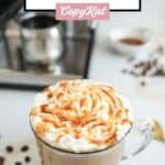 Homemade Starbucks caramel latte and an espresso machine behind it.