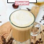 Homemade Starbucks vanilla latte and coffee beans on a wood board.