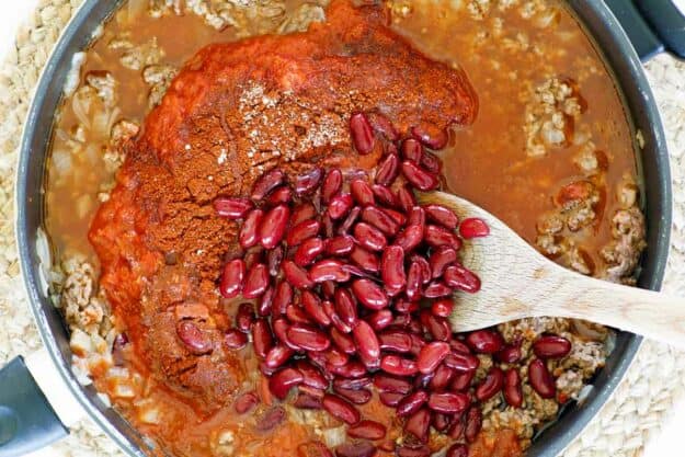 Steak and Shake chili with beans being cooked in a skillet.
