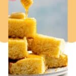 Homemade Tippin's cornbread stacked on a plate and honey being drizzled over them.