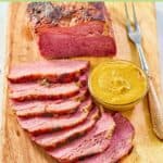 Baked corned beef, mustard, and carving fork.