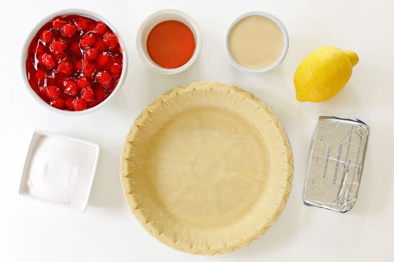 Cherry cream cheese pie ingredients on a marble surface.