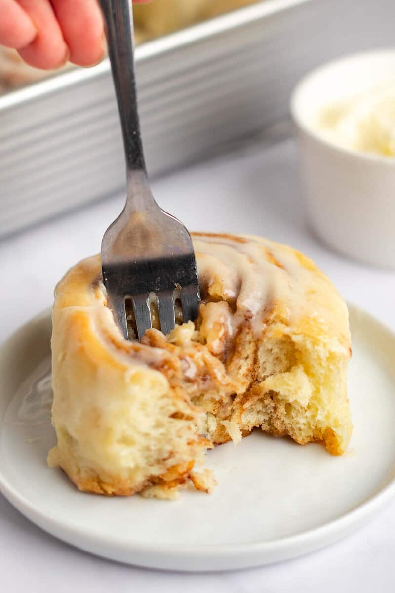 Copycat Cinnabon cinnamon roll on a plate with a fork in it.