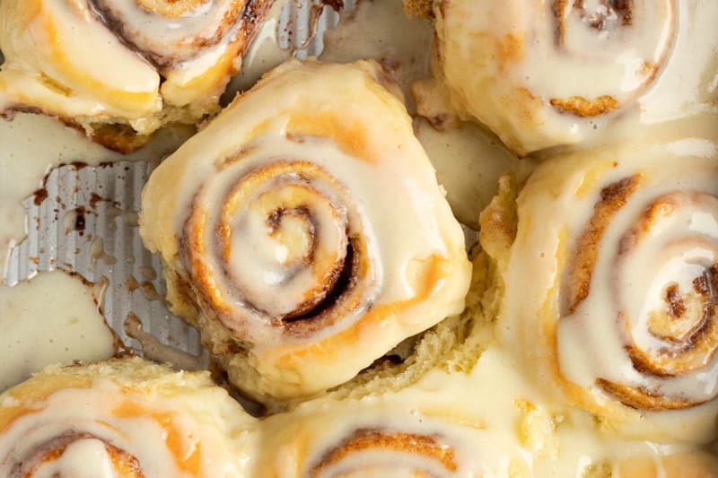 Homemade Cinnabon cream cheese frosting on cinnamon rolls.