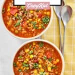 Two spoons and two bowls of cowboy soup.