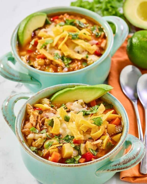 Copycat El Torito's chicken tortilla soup in two bowls.