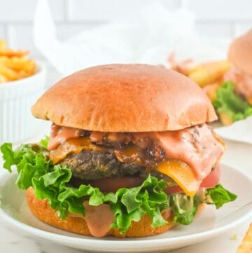 Copycat In-N-Out animal style burger on a plate and fries beside it.