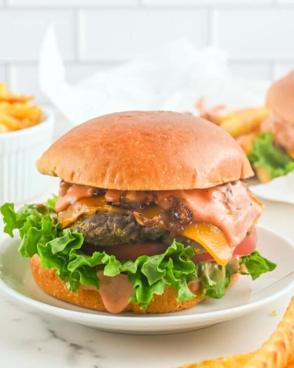 Copycat In-N-Out animal style burger on a plate and fries beside it.